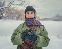 a woman holding a camera in the snow